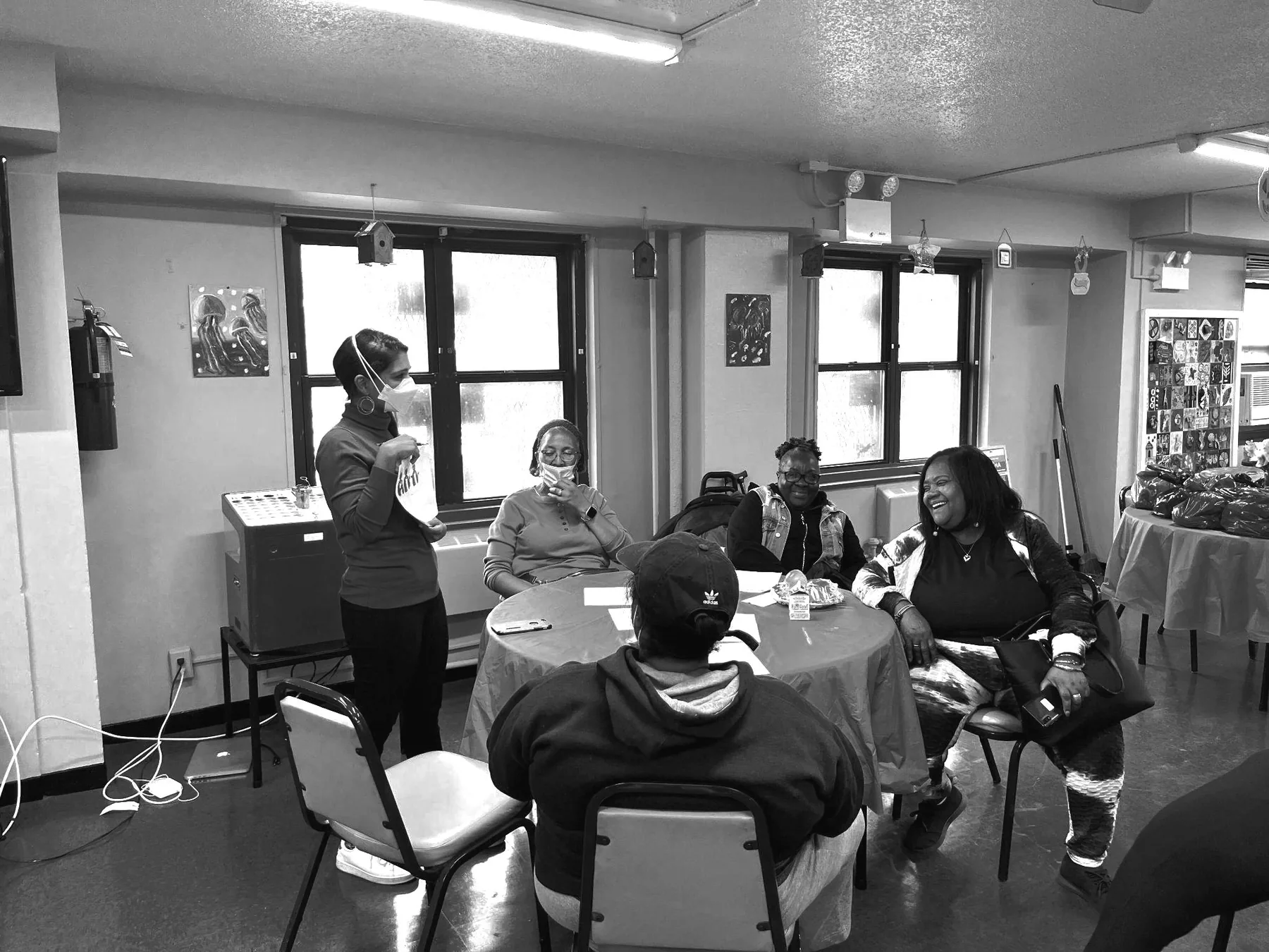 Older adults laughing together around a table at a community session