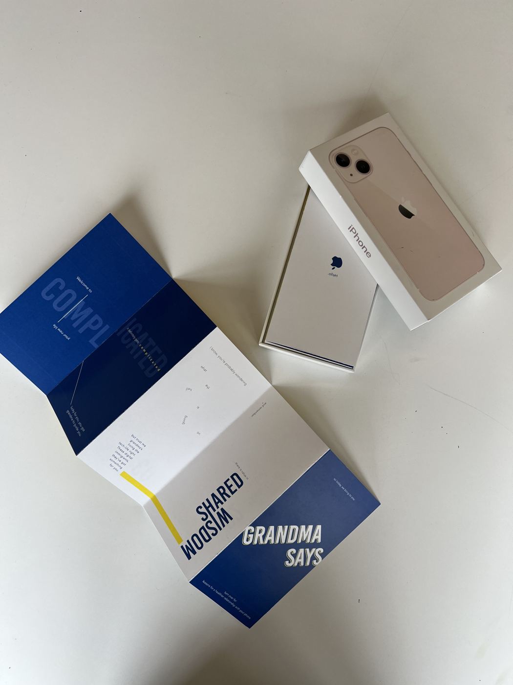 The manual laid out beside a new iPhone in its box