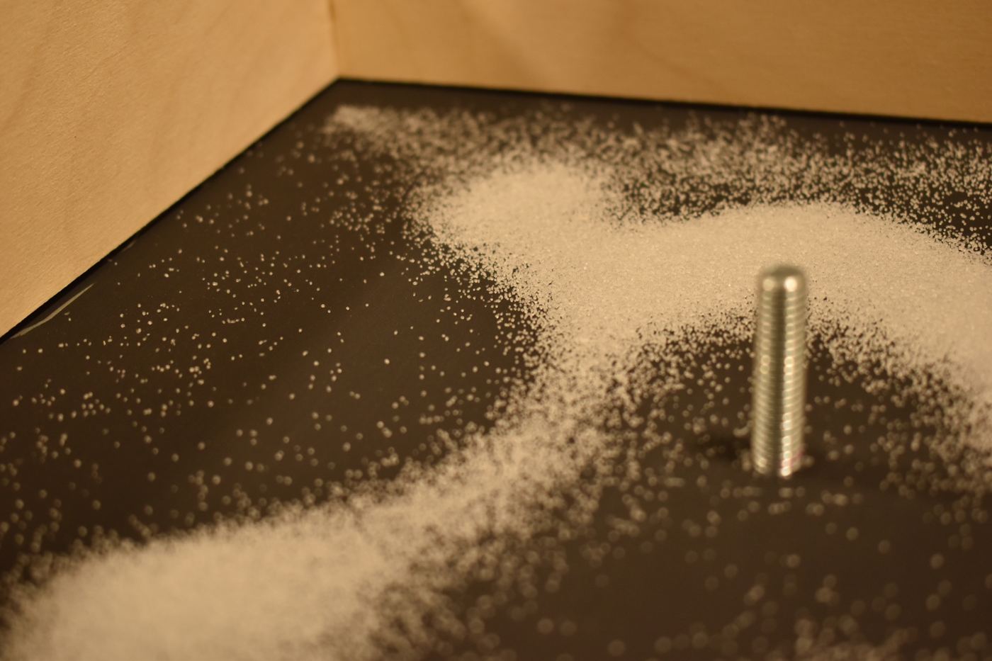 Close-up of sand drifting around the bolt at the centre of the plate